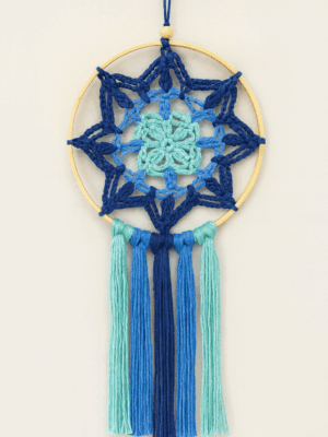 Mandala cuadrado azul artesanal con aro de madera, tejido a crochet en tonos marinos.