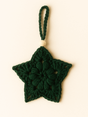 Estrella de Navidad tejida a mano en hilo de algodón natural, con cuenta de madera y colgador trenzado, en color verde.