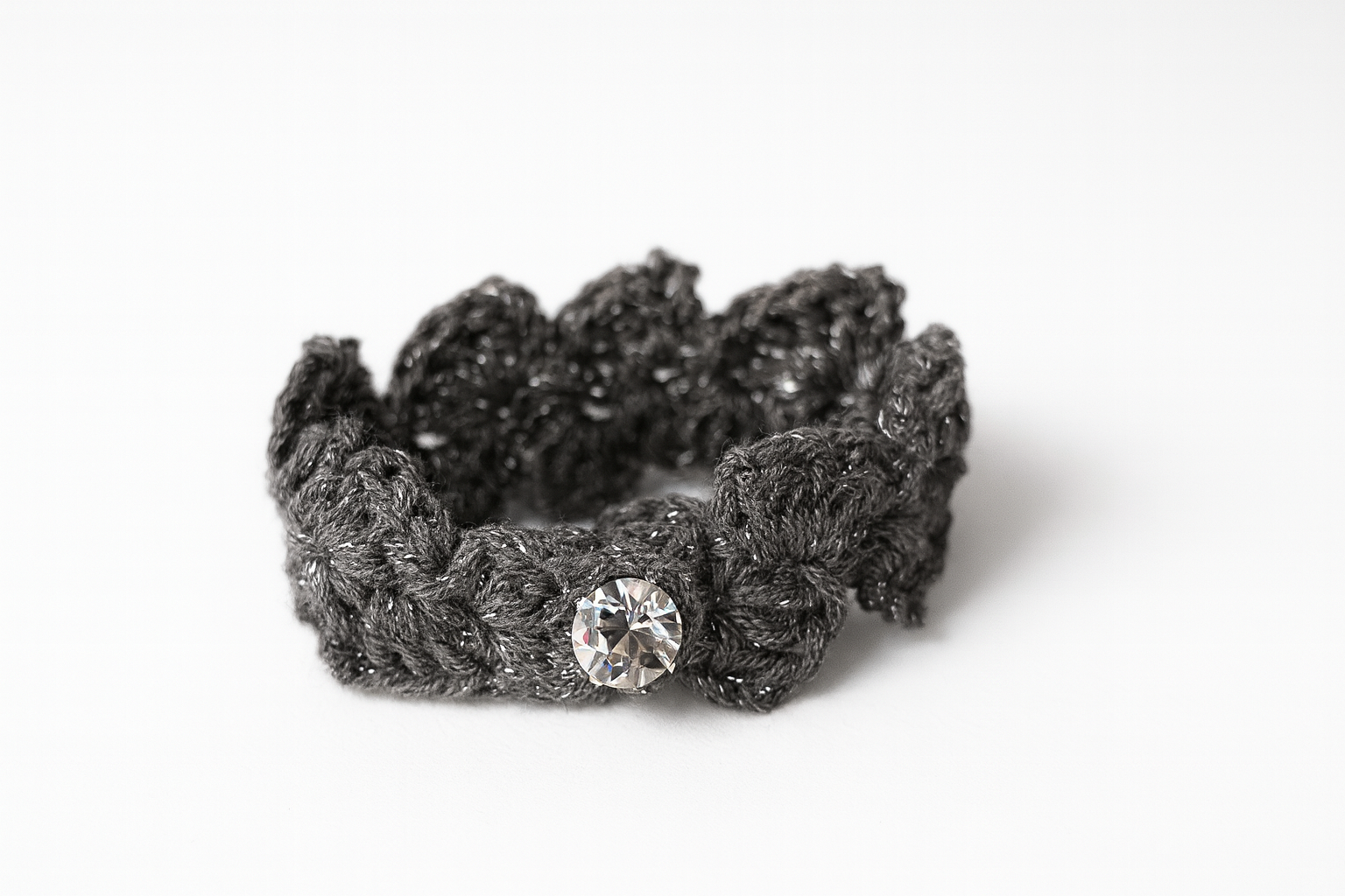 Pulsera artesanal de crochet gris tejida a mano con motivo floral y cierre de botón