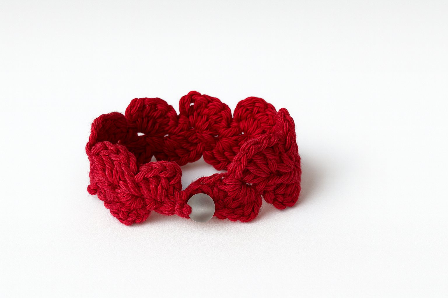 Pulsera artesanal de crochet roja tejida a mano con motivo floral y cierre de botón
