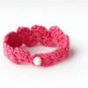 Pulsera artesanal de crochet rosa tejida a mano con motivo floral y cierre de botón