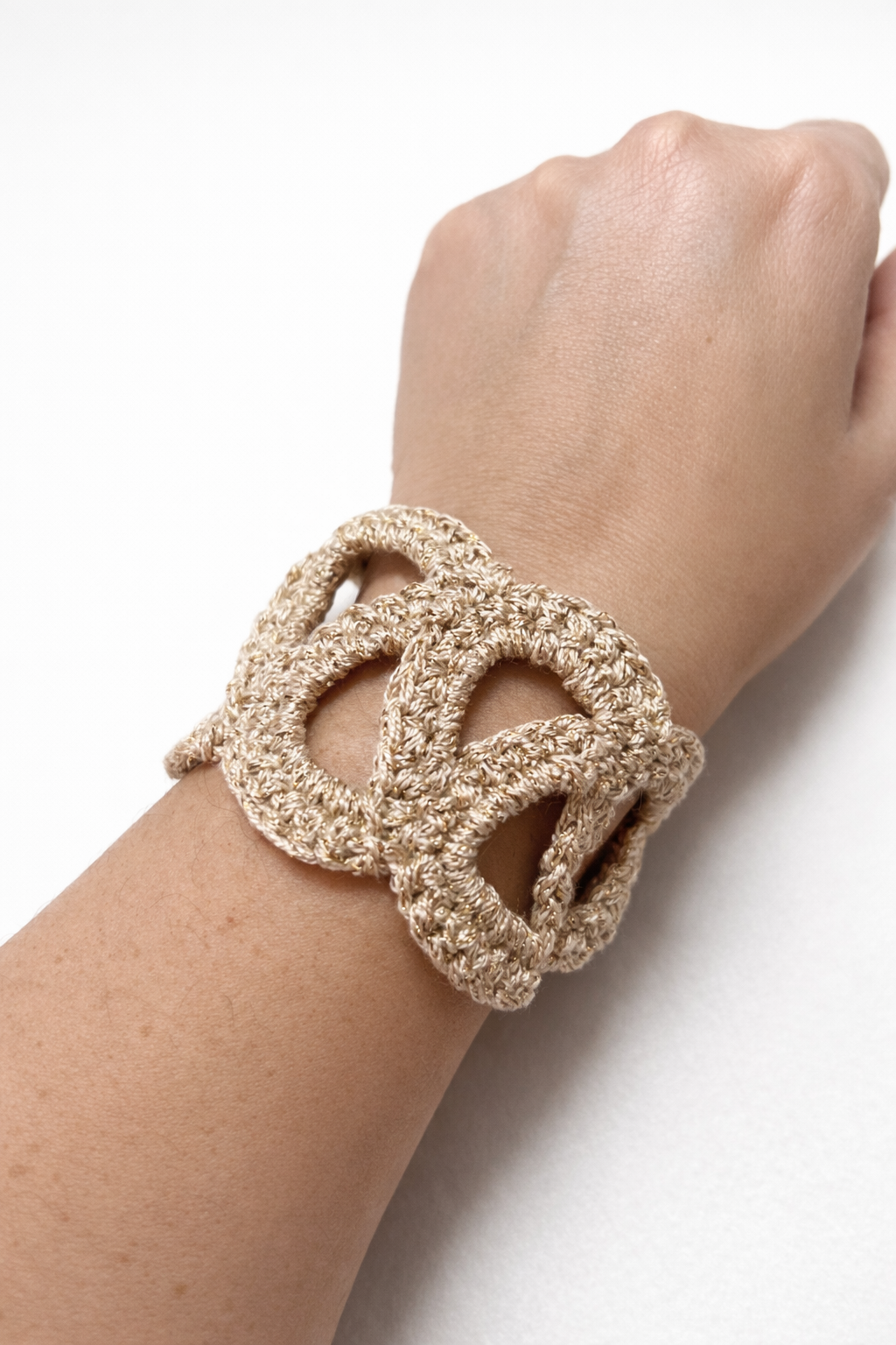 Pulsera Unión de crochet en color beige fotografiada sola sobre fondo claro.