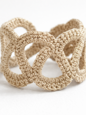 Pulsera Unión de crochet en color dorado fotografiada sola sobre fondo claro.